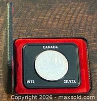 Coin in black holder inside red presentation case