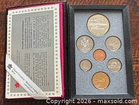 Open case showing all seven coins and certificate