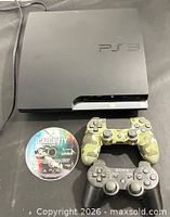 Full lot view showing PS3 Slim, both controllers, game disc