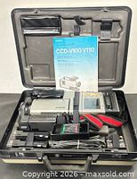Open carrying case showing camcorder, manual, charger, cables and battery