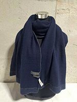 Scarf draped on mannequin showing navy side with label visible