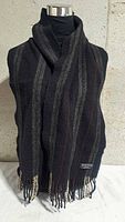 Front view of scarf draped on mannequin showing striped pattern and fringe