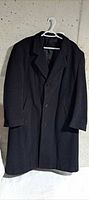 Front view of black Oscar de la Renta overcoat on hanger