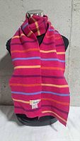 Full view of multicoloured striped wool scarf draped on mannequin