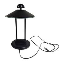 Front angled view of black metal and glass desk lamp with cord