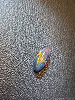 Front view of marquise cabochon Ethiopian black opal showing multicolored play-of-color