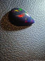 Pear cabochon opal showing red, green flashes