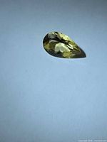 Pear-cut golden yellow Heliodor on neutral background, showing overall shape and color.