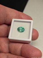 Oval green emerald in display box