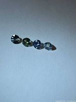 four round multicolour sapphires lined up on white background