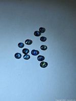 Group of loose round blue sapphires under overhead light