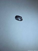 Oval purple spinel on white background