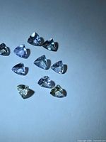 Ten trillion-cut multicolor tanzanites on white background