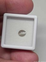 Front view of oval cabochon alexandrite in gem case showing cat’s-eye line