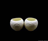 Front view of the pair of ivory ceramic lotus candle holders