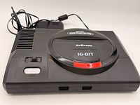 Top view of AtGames Sega Genesis Flashback console showing power and reset buttons, cartridge slot cover, and attached power cable