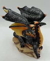 Front view of glittered black dragon on rock base
