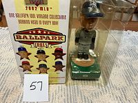 Front view of boxed Roger Clemens bobblehead beside graphic side of box