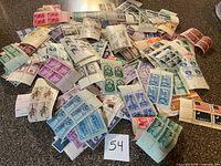 Wide view of mixed unused U.S. stamp blocks spread on surface