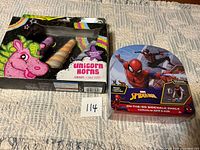 Both sealed chalk sets: Spider-Man tin case and Unicorn Horns box