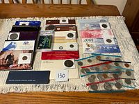Overview of all boxed coin sets, loose coins, graded card and special mint set on table