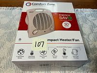 Front of box showing Comfort Zone compact heater/fan model CZ25E and Energy SaveE details
