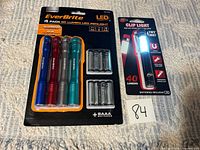 Packaged EverBrite 4-pack LED penlights with batteries and packaged 40-lumen clip light