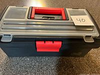 Closed black toolbox with red handle and latch, note dimensions roughly 13 in. wide