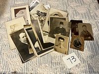 Group view of entire lot of vintage photos spread on surface with lot number 73