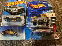 Overview of three unopened Hot Wheels blister packs on table