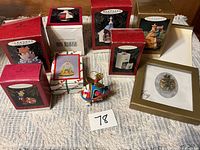 Front view showing nine boxed Hallmark ornaments, loose helicopter ornament and framed Joy piece