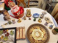 Overall view showing brass plate, framed leaf art, doll, collie dog and assortment of small figurines