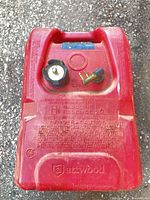 Top view showing Attwood branding, vented cap with gauge, brass fuel outlet, handle