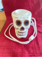 Front view of ceramic sugar skull wax warmer with power cord