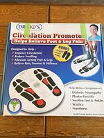 Retail box showing Dr. Ho's Circulation Promoter with images of foot massager pad and mention of bonus travel foot pads