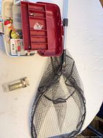Tackle box open, landing net, packaged lure