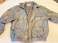 Full view of black faux-leather bomber jacket front side