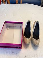 Pair of gold glitter pumps with open shoe box interior