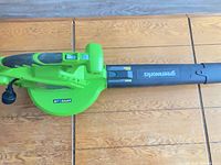 Full view of Greenworks handheld leaf blower showing body, nozzle, attached cord