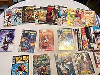 Wide shot of roughly twenty bagged and boarded comics spread on round table
