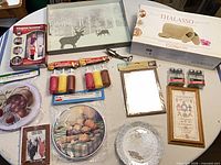 Full assortment of boxed items, framed art, kitchen gadgets and decor on table