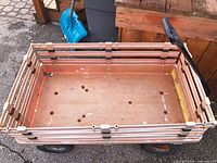 Top view of peach plastic wagon with slat sides and wheels visible