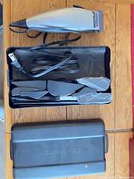 Clipper, coiled cord, accessories in open black case, lid below