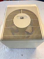 Top view of cream Tempt humidifier showing slotted grille and power button