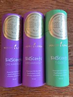 Front view of three sealed KidScents roll-ons: two purple Dreamease, one green T-Gize