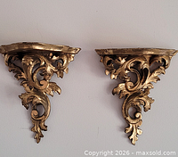 Front view of both gilt wood brackets showing overall design and wear
