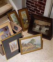 Group of six framed artworks on floor and in box