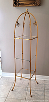 full front view of etagere showing three tiers and arched top