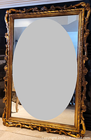 Full view of rectangular gilt mirror standing upright