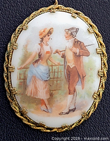 Front view showing painted courting scene and gold-tone frame